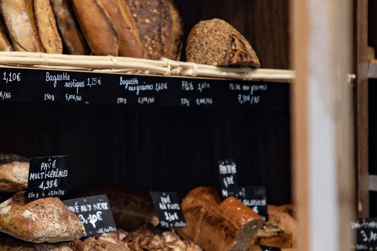Fresh bread loaves on shelves inside a bakery shop counter display