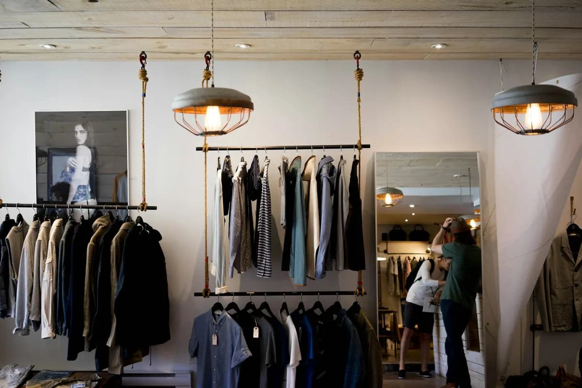Fashion retail store interior with clothing displays and shopper